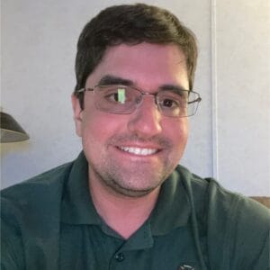 A man wearing glasses and a green shirt delivers a captivating MC Fireside Chat on January 18, 2023.