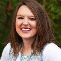 A woman smiling in front of a tree while attending the MC Fireside Chats on September 20th, 2023.