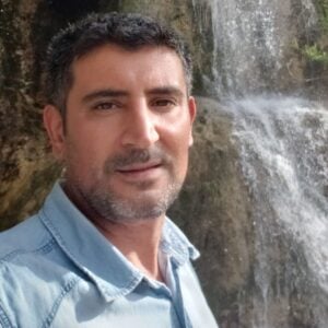 A man standing in front of a waterfall during the MC Fireside Chats on October 4th, 2023.