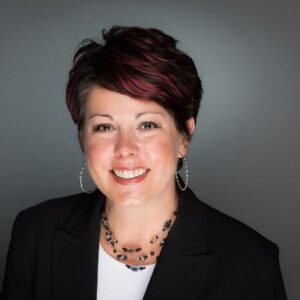 MC Fireside Chats - A woman in a black blazer smiles for the camera during an engaging conversation.