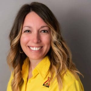 A smiling woman in a yellow shirt during the MC Fireside Chats on November 15th, 2023.