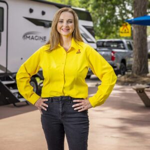 A woman in a yellow shirt standing in front of an rv, November 15th.
