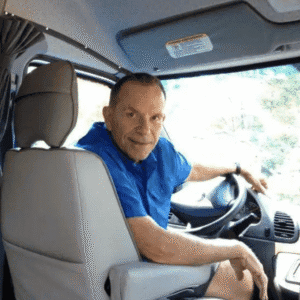 Description: A man sitting in the driver's seat of a van while engaged in MC Fireside Chats.