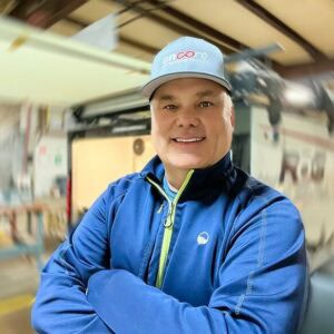 Man in a blue jacket and cap smiling at the MC Fireside Chats in a workshop setting on March 27th, 2024.